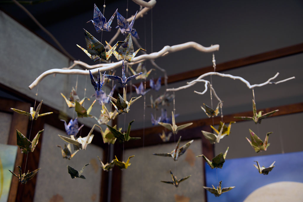 paper cranes fly above booth